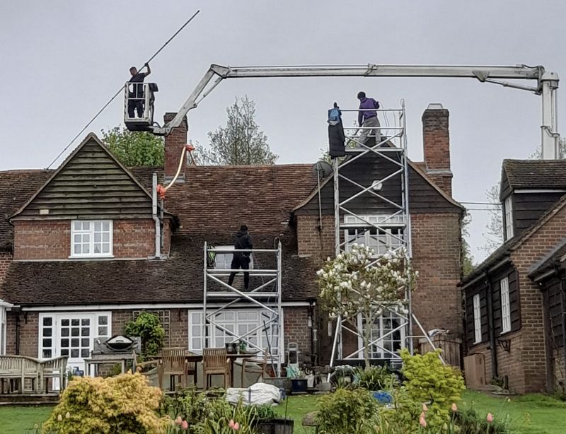 The Moss Cleaners using cherry picker and scaffolding to clean roof safely and professionally in Southfields, London